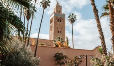 View of the Koutoubia Mosque tower surrounded by lush gardens in Marrakech, Morocco.
