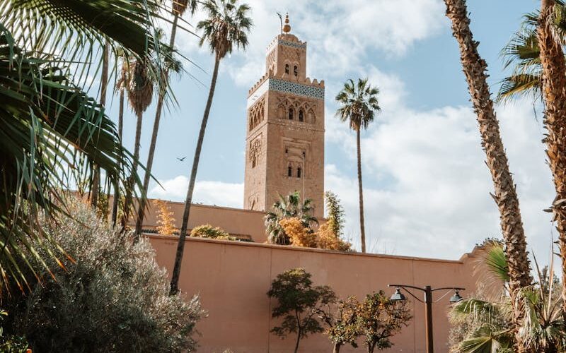 View of the Koutoubia Mosque tower surrounded by lush gardens in Marrakech, Morocco.