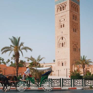 a horse drawn carriage in front of a tall tower