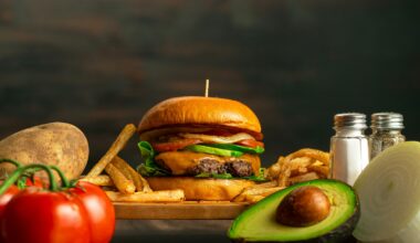 a hamburger, french fries, avocado, tomato, onion, and salt